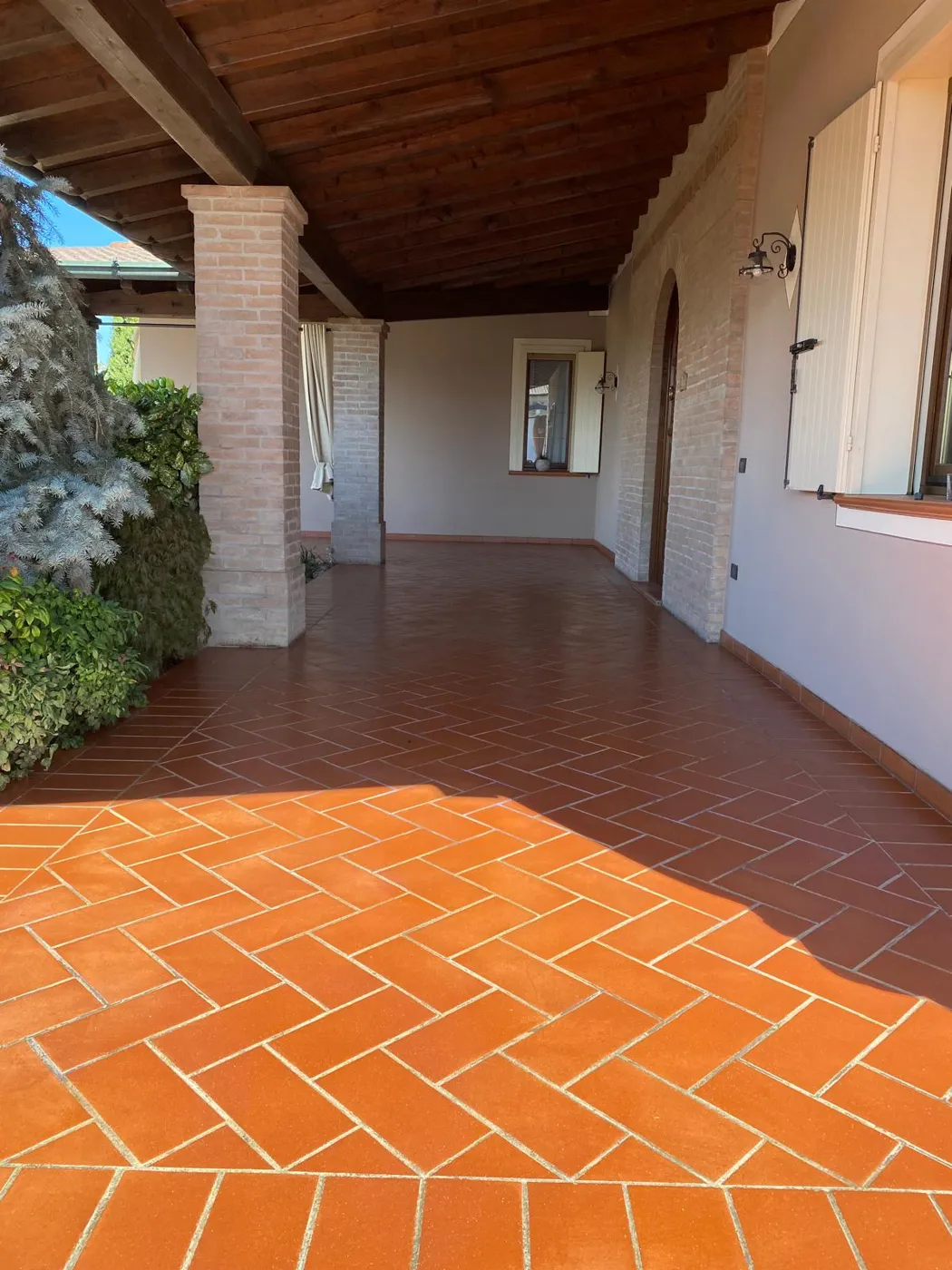 Portico con pavimento in cotto a spina di pesce lavato e trattato in Lombardia